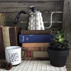 a stack of books and a coffee pot on a table