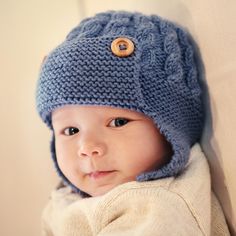 a small child wearing a blue knitted hat