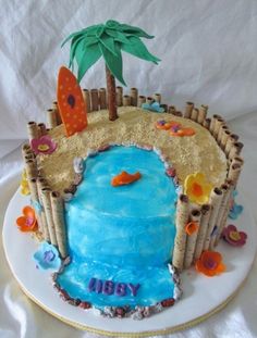 a birthday cake decorated with an ocean scene and palm tree