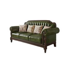 a green leather couch with pillows on it's arm and back cushions, in front of a white background