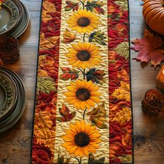 a table runner with sunflowers and leaves on it, next to plates and candles