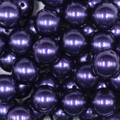 many shiny purple balls are stacked on top of each other