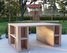 a wooden table sitting on top of a cement ground