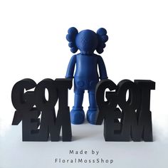 a blue teddy bear standing next to some black letters