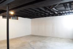 an empty room with white walls and black pipes