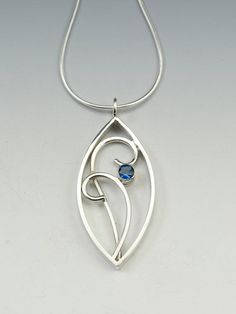 Sterling silver hand fabricated filigree pendant measures 1.5" high and 3/4" wide, offset with a faceted 5mm London Blue Topaz gemstone accent and hung from a 1mm snake chain.  Simple and elegantI can use other gemstones upon request, or a birthstone, message me for pricing.Created from responsibly sourced materials where possible. Each piece is handmade, because of this there may be slight variations in your finished piece from the photo shown. Please allow 1-2 weeks for fabrication and deliver Modern Silver Jewelry With Birthstone, Sterling Silver Jewelry With Polished Snake Chain, Sterling Silver Snake Chain Jewelry With Polished Finish, Blue Topaz Teardrop Pendant Jewelry For Anniversary, Blue Topaz Teardrop Pendant For Anniversary, Sterling Silver Polished Flower Pendant Jewelry, Silver Oval Pendant Jewelry With Blue Topaz, Silver Sapphire Oval Pendant Jewelry, Silver Oval Blue Topaz Pendant Jewelry