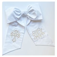 two white bow ties with gold monogrammings on the front and one in the back