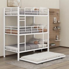 a white bunk bed sitting on top of a hard wood floor next to a wall