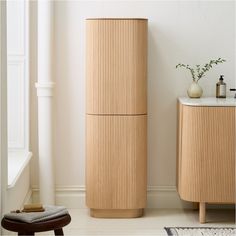 a tall wooden cabinet sitting next to a white wall in a room with a rug on the floor