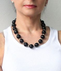 "This black onyx statement beaded necklace is an elegant combination. It gives this necklace its rich, sophisticated look. I hand selected high quality black onyx 14mm round gemstones, and set each stone with small 3mm sterling silver beads for a classic elegant look. The black onyx gemstones are separated by small silver-plated beads in this lovely necklace while a silver lobster clasp completes the design.  This single strand onyx necklace will go with everything in your wardrobe.  It is a stu Onyx Necklace Simple, Elegant Black Beaded Necklaces With Gemstone Beads, Elegant Black Beaded Necklace With Gemstone Beads, Black Single Strand Beaded Necklaces For Party, Black Single Strand Beaded Necklace For Party, Classic Black Necklace For Party, Party Black Single Strand Beaded Necklace, Classic Onyx Beaded Necklace With Black Beads, Classic Black Beaded Necklaces With Polished Beads