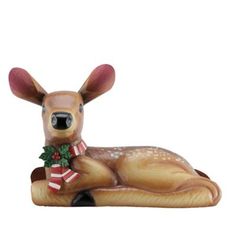 a ceramic deer laying down with a christmas decoration