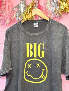 a t - shirt with the words big on it hanging from a clothes hanger