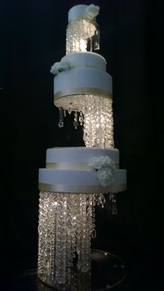 a three tiered wedding cake with white flowers and icing on the bottom layer