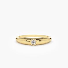 a yellow gold ring with a single diamond on the center, and a white background