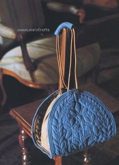 a blue purse sitting on top of a wooden table next to a white and black chair