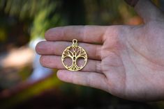 Tree of Life necklace. This pendant has a diameter of 1,2 inches (3 cm) and is crafted by hand in 18k gold. This pendant is a one of a kind design of the 'Tree of Life' symbol. The Tree of Life is an ancient symbol, that has been found in sacred temples all over the world. About the Tree of Life symbol: The Tree of Life is an ancient symbol that has been used all over the world, as a symbol of thriving, harmony, creation and fertility. This one of a kind symbol was designed and created as an ins Spiritual Bronze Jewelry For Anniversary, Symbolic Nickel-free Jewelry For Anniversary, Engraved Bronze Jewelry Gift, Spiritual Round Pendant Jewelry For Anniversary, Spiritual Engraved Pendant Jewelry, Symbolic Engraved Brass Jewelry, Brass Charms Pendant Jewelry, Bronze Engraved Jewelry For Anniversary, Bronze Jewelry With Lobster Clasp For Gift