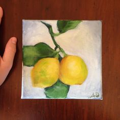 a painting of two lemons with green leaves