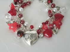 "Red Heart Charm Bracelet This beautiful bracelet has glass pearl beads, red glass beads, silver plated bead caps, lucite flower beads, sterling silver plated chain and pewter silver charms. 7\" long can be adjusted to 9\". Silver plated lobster clasp." Cheap Vintage Jewelry For Valentine's Day, Elegant Beaded Charm Bracelet For Valentine's Day, Valentine's Day Elegant Beaded Charm Bracelet, Valentine's Day Beaded Metal Jewelry, Elegant Beaded Bracelets With Charms For Valentine's Day, Elegant Metal Beaded Bracelets For Valentine's Day, Handmade Red Charm Bracelet For Valentine's Day, Heart-shaped Beaded Bracelets For Valentine's Wedding, Heart-shaped Beaded Bracelets For Wedding On Valentine's Day