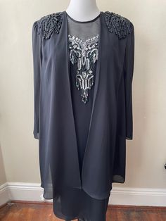 "Vintage made in USA black evening dress with sheer cape sleeves, beaded shoulders, chest appliqué. Marked size 18, made by Speed Fashion, will fit an XL comfortably.  Please ask questions!  Measurements (laid flat):  Tag Size: 18 Length: 45\" Pit to Pit: 23\"x2 Waist: 21\"x2 Hips: 24\"x2 Condition: Excellent vintage condition, no issues noted.  The vintage pieces I sell have all led a previous life and may tell their stories through minor imperfections. I'll do my best to indicate overall condition, but please refer to the pictures. Your purchase continues the life of this garment...what stories will you tell while wearing it?  Please note there may be a slight difference in color when comparing the actual garment to the monitor image. (0290)" Black Cape Dress, Sheer Cape, Black Evening Dress, Black Cape, Dress With Sequins, Cape Sleeves, Black Evening Dresses, Cape Dress, Previous Life