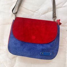 A petite version of everyone's favorite Lola bag, Leo gives you two styles from one purse! With a simple flip of the flap you've got a whole new look. All pictures show the same purse! Made from gorgeous suede, one side of the bag has a wine colored body with a cheetah print hair-on-hide flap, while the other side is denim blue with a red flap. Style it any way you like for a playful look with any outfit. Leo has two spacious compartments, one with an interior zip pocket, and the flippy flap has a magnetic closure on both sides. The adjustable strap makes it perfect to wear as a crossbody. Leo Bag: 8.5" W x 6.5" H x 2" D Adjustable Strap 50" Long View entire Soruka collection This is a one-of-a-kind piece created, designed, and manufactured by hand using discarded, leftover, or no longer i Versatile Rectangular Suede Bag, Trendy Bags With Magnetic Closure For Everyday Use, Trendy Everyday Bags With Magnetic Closure, Rectangular Flap Bag With Snap Closure For Everyday Use, Suede Shoulder Bag With Magnetic Closure For Daily Use, Daily Use Suede Shoulder Bag With Magnetic Closure, Everyday Rectangular Flap Bag With Snap Closure, Suede Bag With Adjustable Strap For On-the-go, Suede Shoulder Bag With Detachable Strap For Daily Use