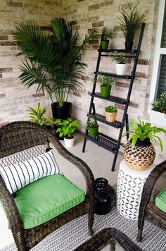 two wicker chairs sitting next to each other on a porch with potted plants