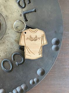 a wooden keychain with a t - shirt on it