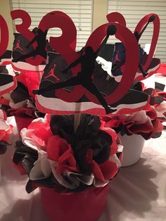 the table is decorated with red and black paper flowers, which have been placed in buckets