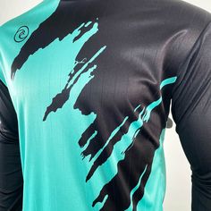 the back of a man's shirt with black and turquoise paint on it,