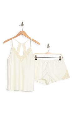 Perfect for romantic evenings, this elegant pajama set crafted in smooth matte satin includes a lace-trimmed racerback camisole and matching shorts. 2-piece set Top has V-neck; adjustable straps; open racerback; scalloped lace trim; satin construction Shorts have elastic waist; scalloped lace trim; satin construction 100% polyester Hand wash, dry flat Imported Model stats: 5'10" height, 32" bust, 25" waist, 36" hip. Model is wearing size S. Feminine Cami Sleepwear For Night, Feminine Sleeveless Sleep Sets, Elegant Camisole Sleep Sets, Elegant Sleep Sets With Camisole, Spring Bedtime Camisole Set, Feminine Sleeveless Loungewear Sets, Summer Night Lace Trim Sets, Spring Sleeveless Night Sets, Summer Night Sets With Spaghetti Straps