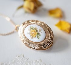 Yellow Rose Gold Oval Photo Locket. A lovely 30mm x23mm oval locket is adorned with a beautiful vintage Japanese floral porcelain cabochon (18mmx13mm) with yellow rose design. The locket is in gold finish with beautiful etched design on both front and back. The locket can open to hold two photos or small treasures. PERSONALISATION We can personalize this locket by adding 1 or 2 photos for you. You can also choose to add photo (s) on your own. Please choose the options from drop-down menu. How to Oval Locket Necklaces For Mother's Day, Mother's Day Oval Locket Necklaces, Oval Rose Design Jewelry For Wedding, Oval Locket Necklace For Mother's Day, Oval Cameo Keepsake Jewelry, Vintage Oval Jewelry With Rose Design, Vintage Oval Pendant Jewelry For Mother's Day, Cameo Locket Necklace As Gift, Oval Cameo Locket Necklace Gift