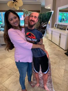 a man and woman hugging each other in the living room