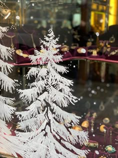 a white christmas tree is in a glass case