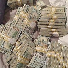 a pile of money sitting on top of a bed