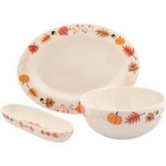 three white dishes with autumn leaves and pumpkins painted on the side, one bowl is empty