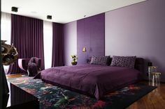 a bed room with a neatly made bed and purple walls