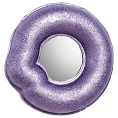 a purple donut shaped mirror sitting on top of a white table next to it's reflection