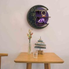 a wooden table topped with a vase filled with purple flowers next to a clock on the wall