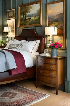 a bedroom with green walls and paintings on the wall above it, along with a bed