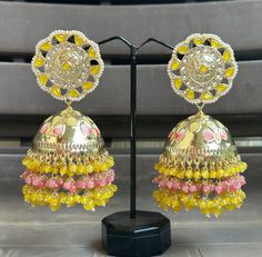 Big statement Jhumka earrings featuring a stunning yellow and pink colour combo! The gold Kundan accents make these earrings look absolutely Royal and beautiful. They are sure to impress anyone paired with an ethnic outfit! Luxury Bollywood Multicolor Jhumkas, Luxury Multicolor Bollywood Jhumkas, Elegant Yellow Jhumkas For Festive Season, Elegant Yellow Jhumkas For Wedding, Festive Yellow Elegant Jhumkas, Yellow Latkans Earrings For Wedding, Elegant Yellow Chandbali Jhumkas, Multicolor Chandbali Earrings With Gota Work, Fusion Style Festive Jhumkas With Gota Work