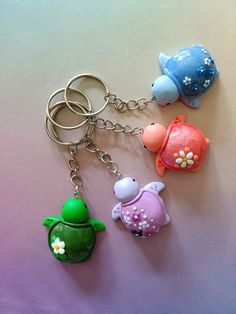 three keychains with different designs on them sitting next to each other in the shape of animals