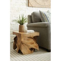 a wooden table sitting in front of a couch with a potted plant on it