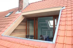 a man is sitting in the window of his house looking out at the street below