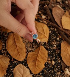 Design by ManhattanBox ITEM DESCRIPTION ✦Teal Sapphire engagement ring ✦Available in yellow, white or rose solid 14 or 18k gold. ✦Band width approx 1.2mm ✦Band thickness approx 1.2mm Center Stone: Natural Teal Sapphire Shape: Oval Size: 6*8mm Accent Stone: Diamond Shape: Round Carat: 0.06ct Total Weight: about 2.52g A leaf-shaped and hollowed-out prong setting liberates the glowing of the gemstone from every angle, and a ring band in the shape of branches with leaves dotted with side accents mak Open Ring Topaz Wedding Jewelry, Topaz Open Ring Jewelry Gift, Rose Gold Rings With Accent Stones For Gifts, Topaz Crystal Open Ring Gift, Topaz Solitaire Ring As A Gift, Topaz Solitaire Ring Gift, White Gold Open Topaz Ring For Gift, White Gold Topaz Open Ring For Gift, Rose Gold Topaz Ring With Accent Stones For Gift