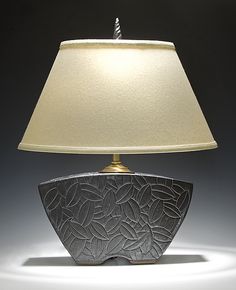 a table lamp with a white shade on it's base and a light in the middle