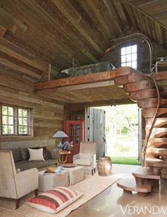 a living room filled with furniture and a spiral staircase