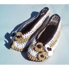 pair of crocheted slippers with brown and white trims on snow covered ground