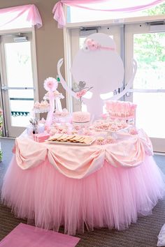 a table with pink and white desserts on it