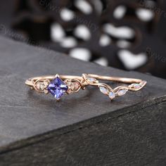 a ring with an amethorate and white stones on the side, sitting on top of a wooden table