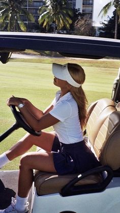 a woman sitting in the drivers seat of a golf cart