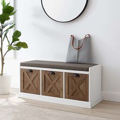 a white bench with wooden drawers underneath a round mirror